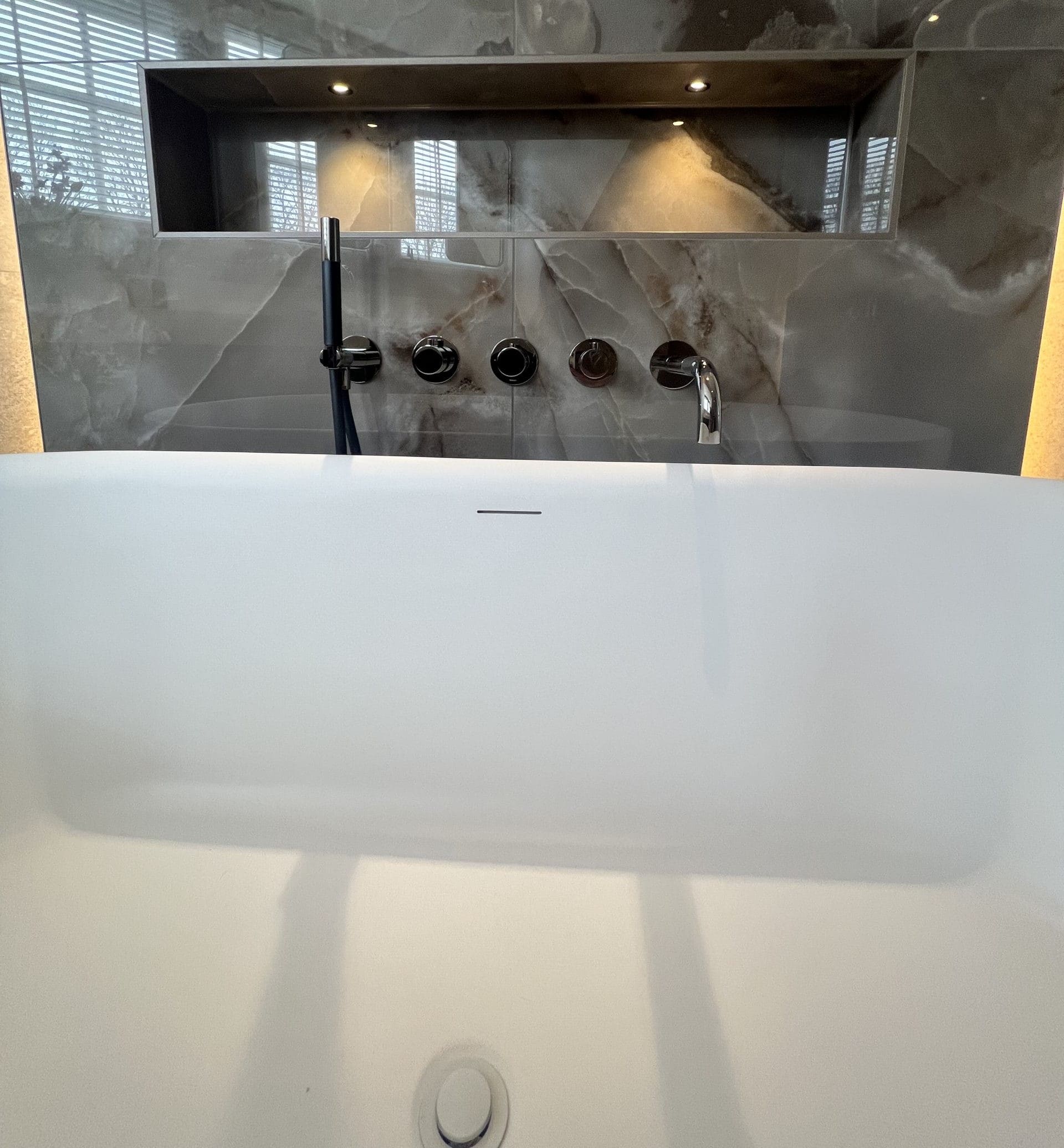 Stijlvolle badkamer: luxe bruine marmerlook gecombineerd met rustige tegels