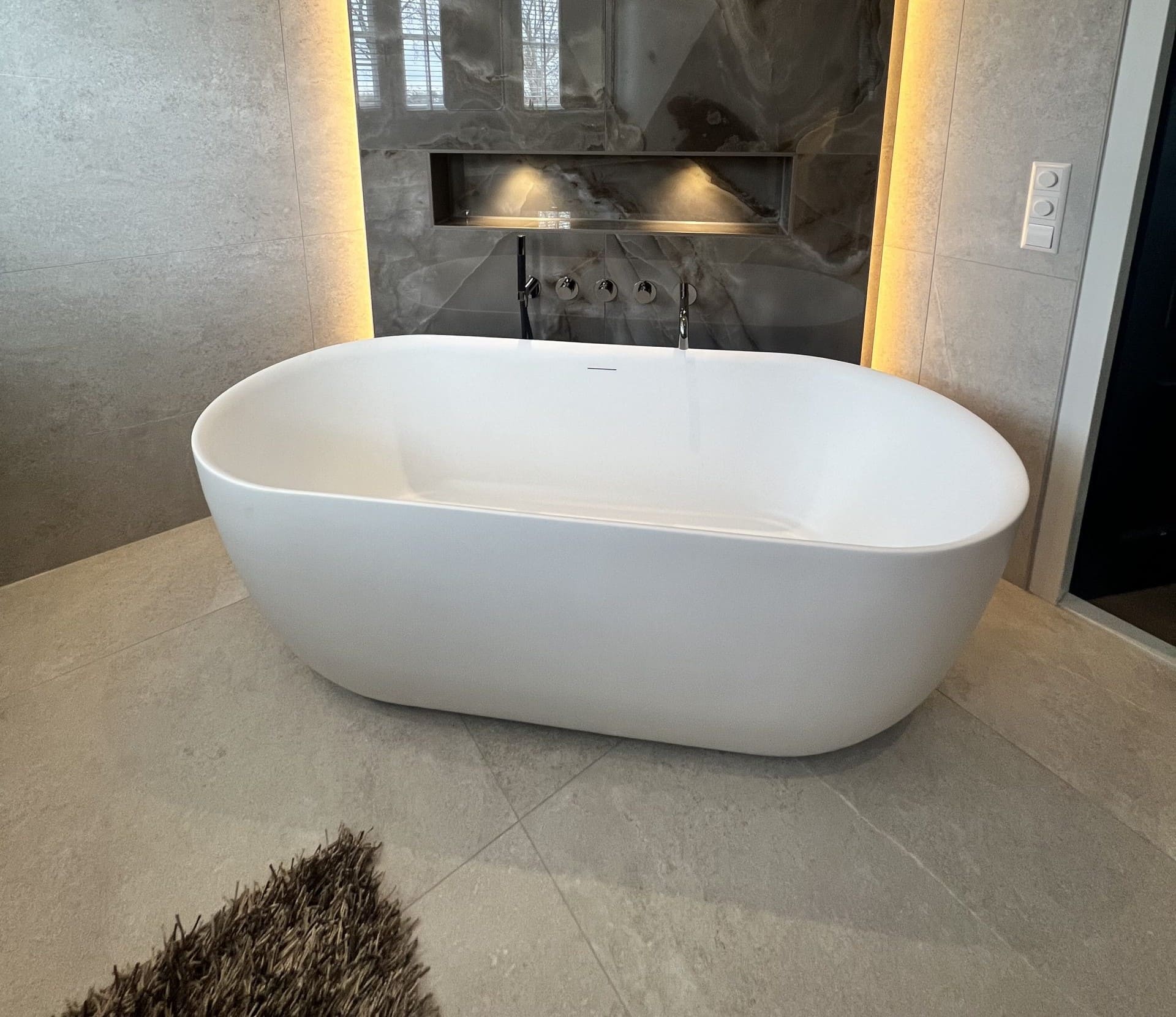 Stijlvolle badkamer: luxe bruine marmerlook gecombineerd met rustige tegels